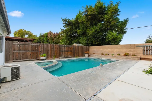 a view of backyard with swimming pool and outdoor seating