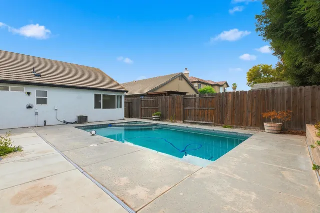 a view of a house with backyard and a tree
