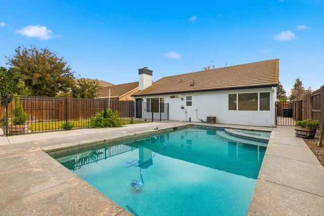 a view of a house with swimming pool and a yard
