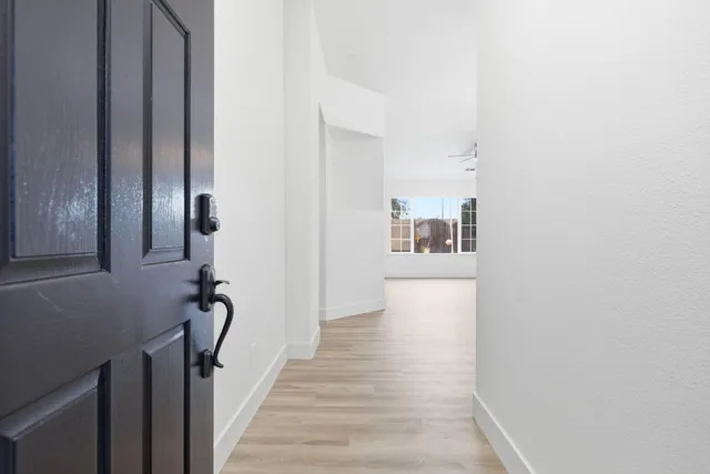 a view of a hallway with wooden floor and stairs