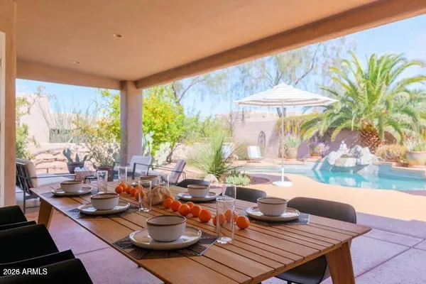 a outdoor dining space with furniture and umbrella