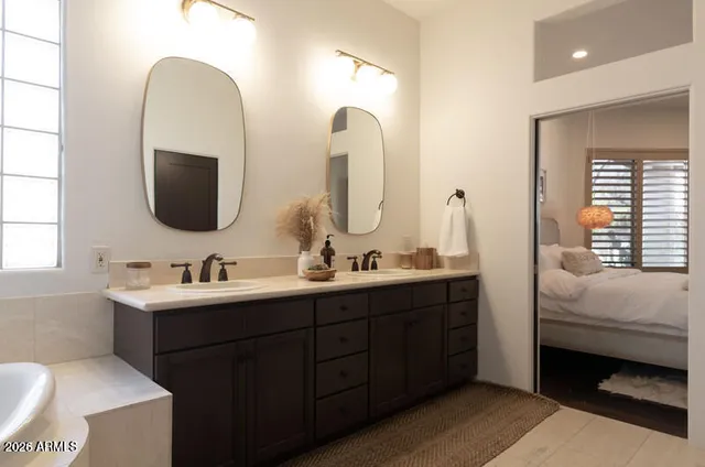 a en suite bathroom with a double vanity sink and a mirror