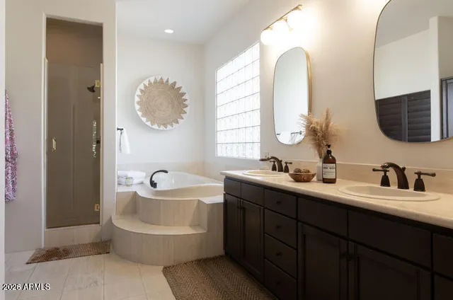 a bathroom with a double vanity sink mirror and bathtub