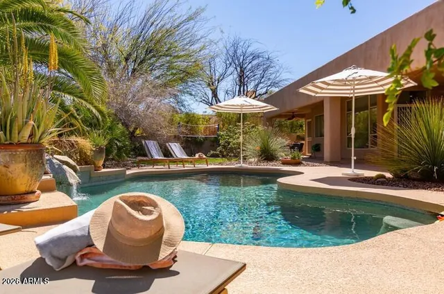 a view of a swimming pool with chair and tables