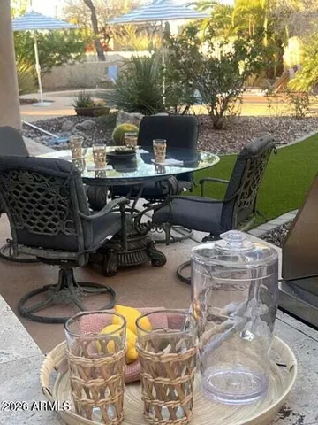 a view of a backyard with table and chairs potted plants