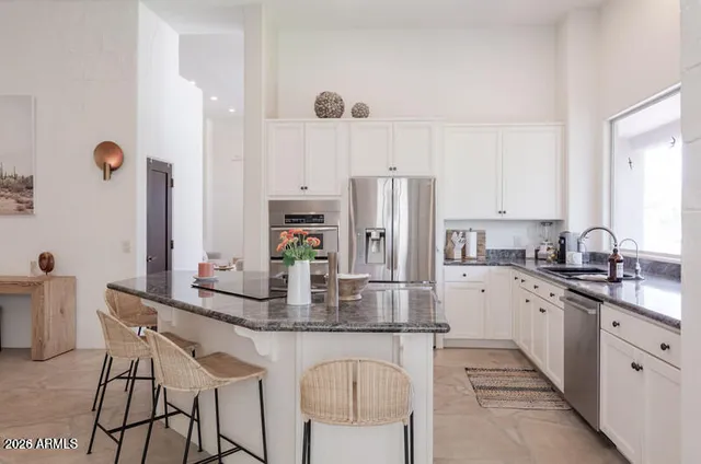 a kitchen with refrigerator a sink and chairs