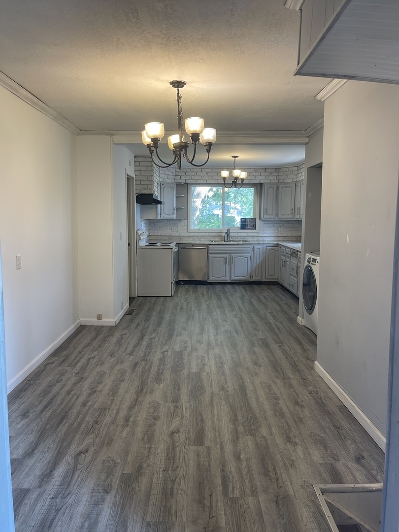 1824 16th Avenue Sterling, IL 61081 - Photo 10 of 26 an empty room with wooden floor and chandelier
