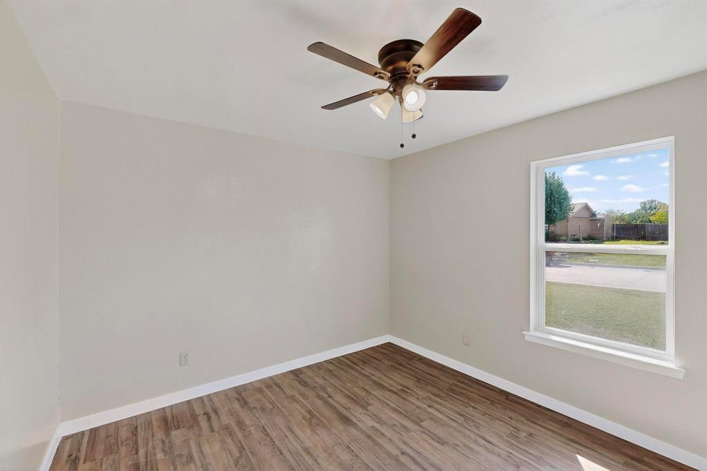 1407 El Camino Circle Princeton, TX 75407 - Photo 11 of 26 an empty room with wooden floor and windows