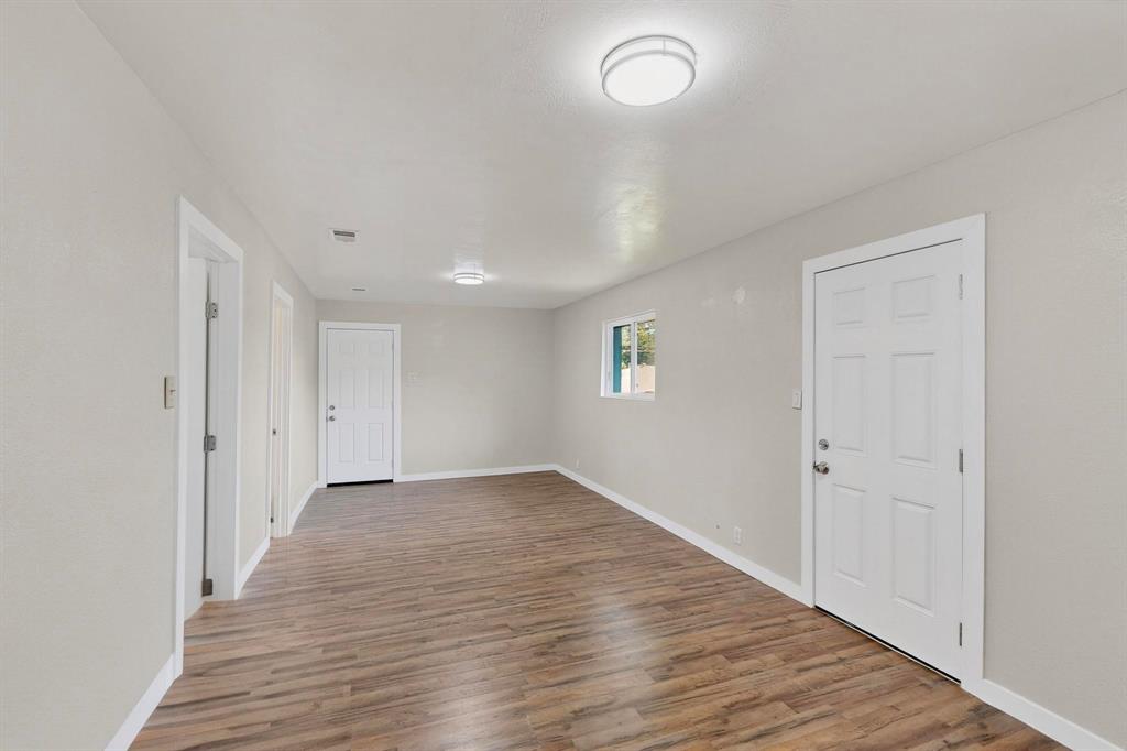 1407 El Camino Circle Princeton, TX 75407 - Photo 20 of 26 an empty room with wooden floor and windows