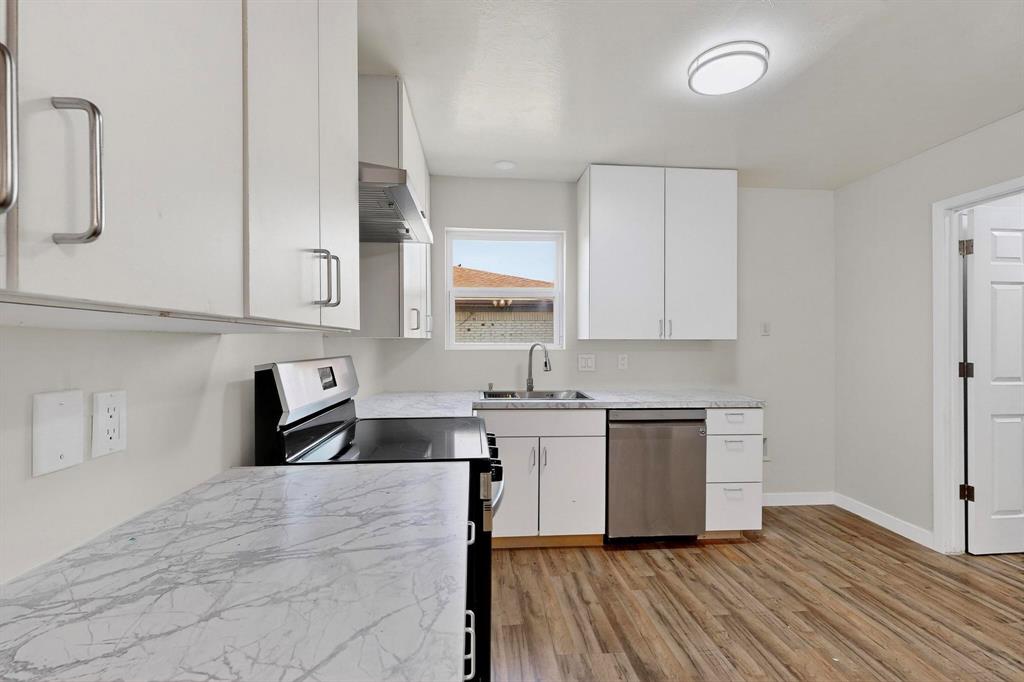 1407 El Camino Circle Princeton, TX 75407 - Photo 7 of 26 a kitchen with granite countertop a stove a sink and a refrigerator