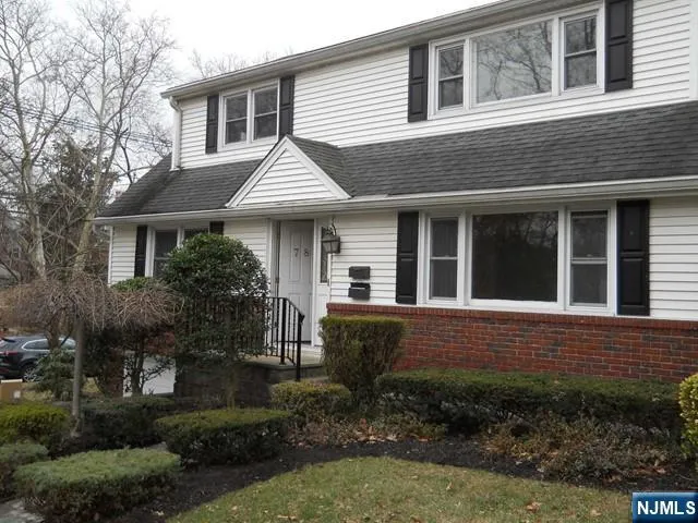 a view of house with a yard and potted plants