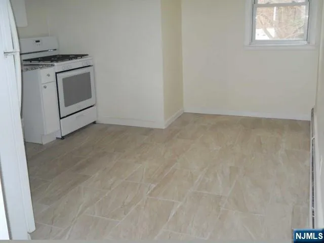 a view of a kitchen with white cabinets and white appliances