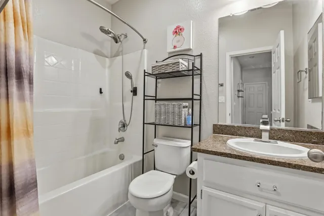a bathroom with a granite countertop sink toilet and shower