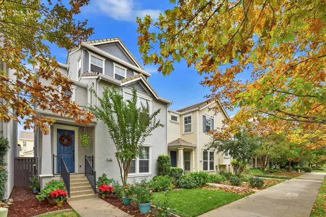 a front view of a house with a tree