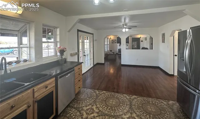a view of a room with wooden floor and ceiling fan