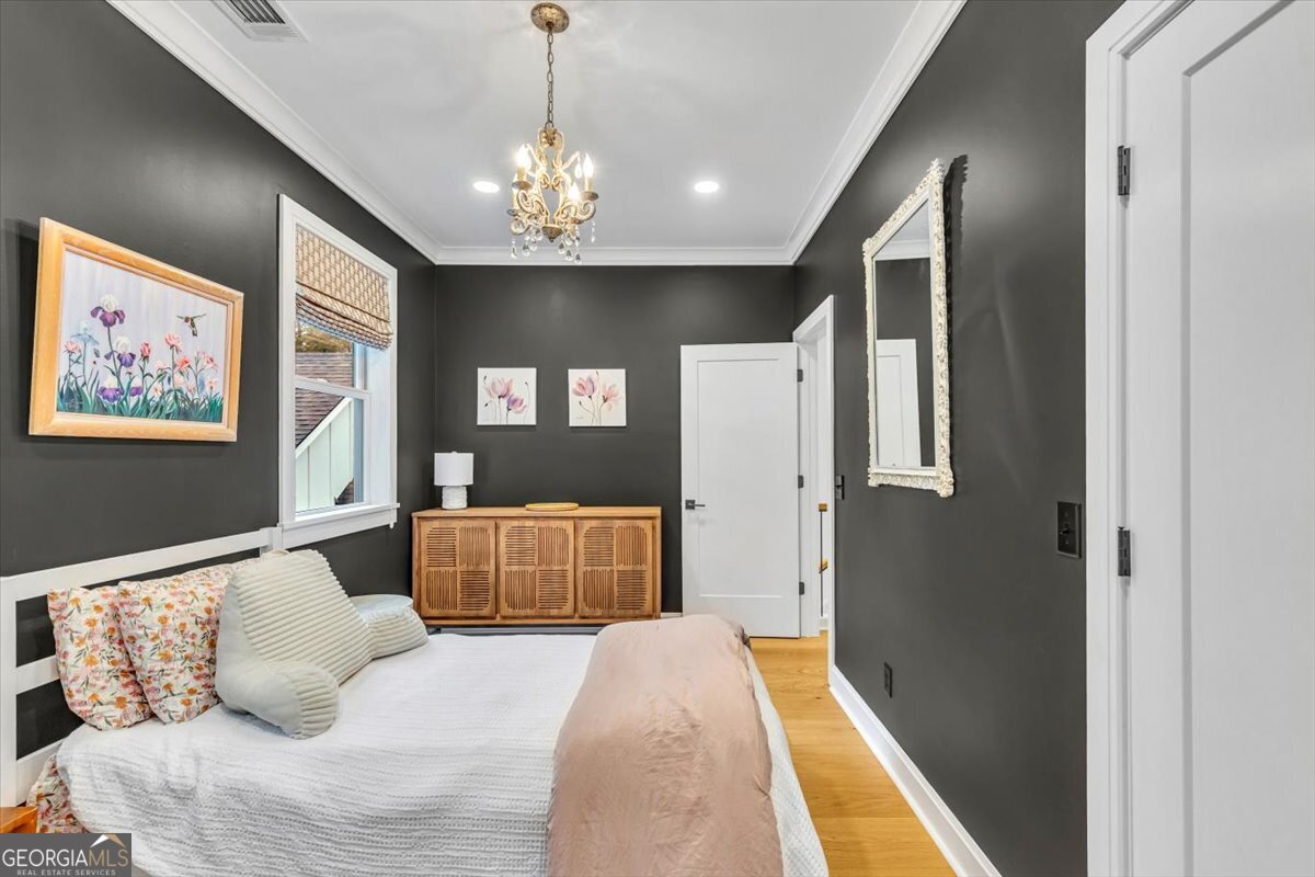 822 Dancy Avenue Savannah, GA 31419 - Photo 56 of 73 a bedroom with a large bed and a chandelier