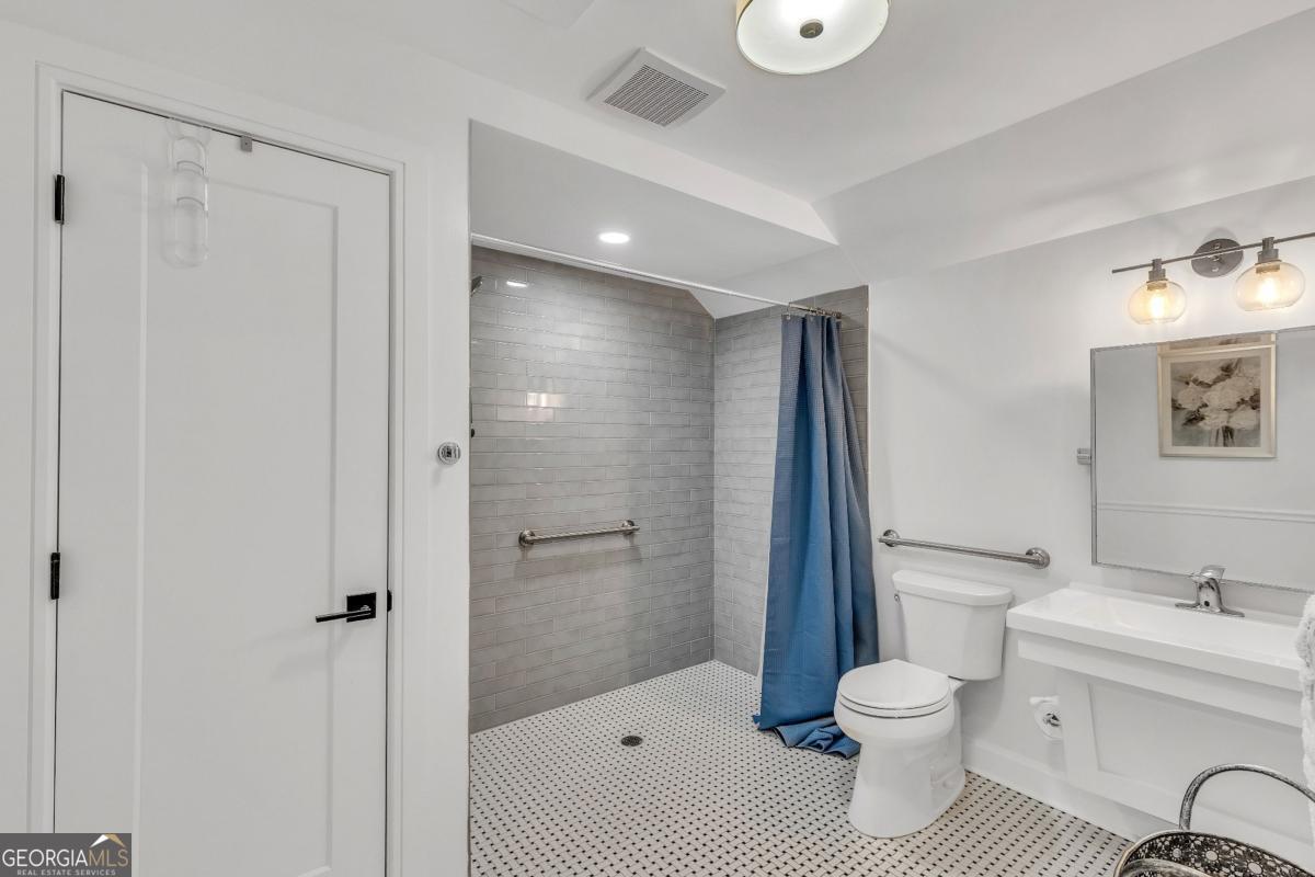 822 Dancy Avenue Savannah, GA 31419 - Photo 67 of 73 a bathroom with a toilet a sink and a large mirror