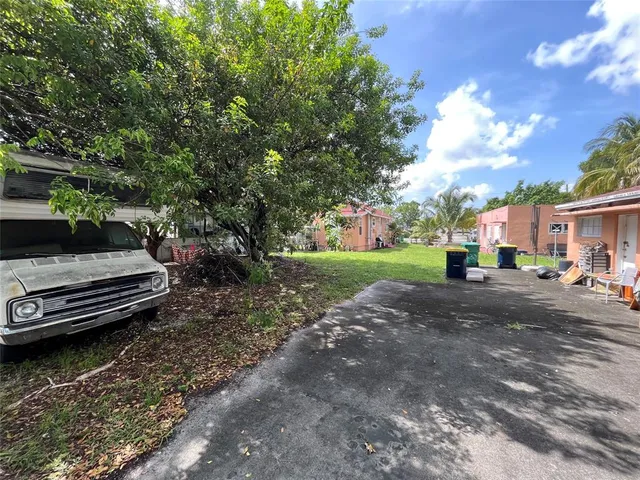 a view of a house with large tree in front of it