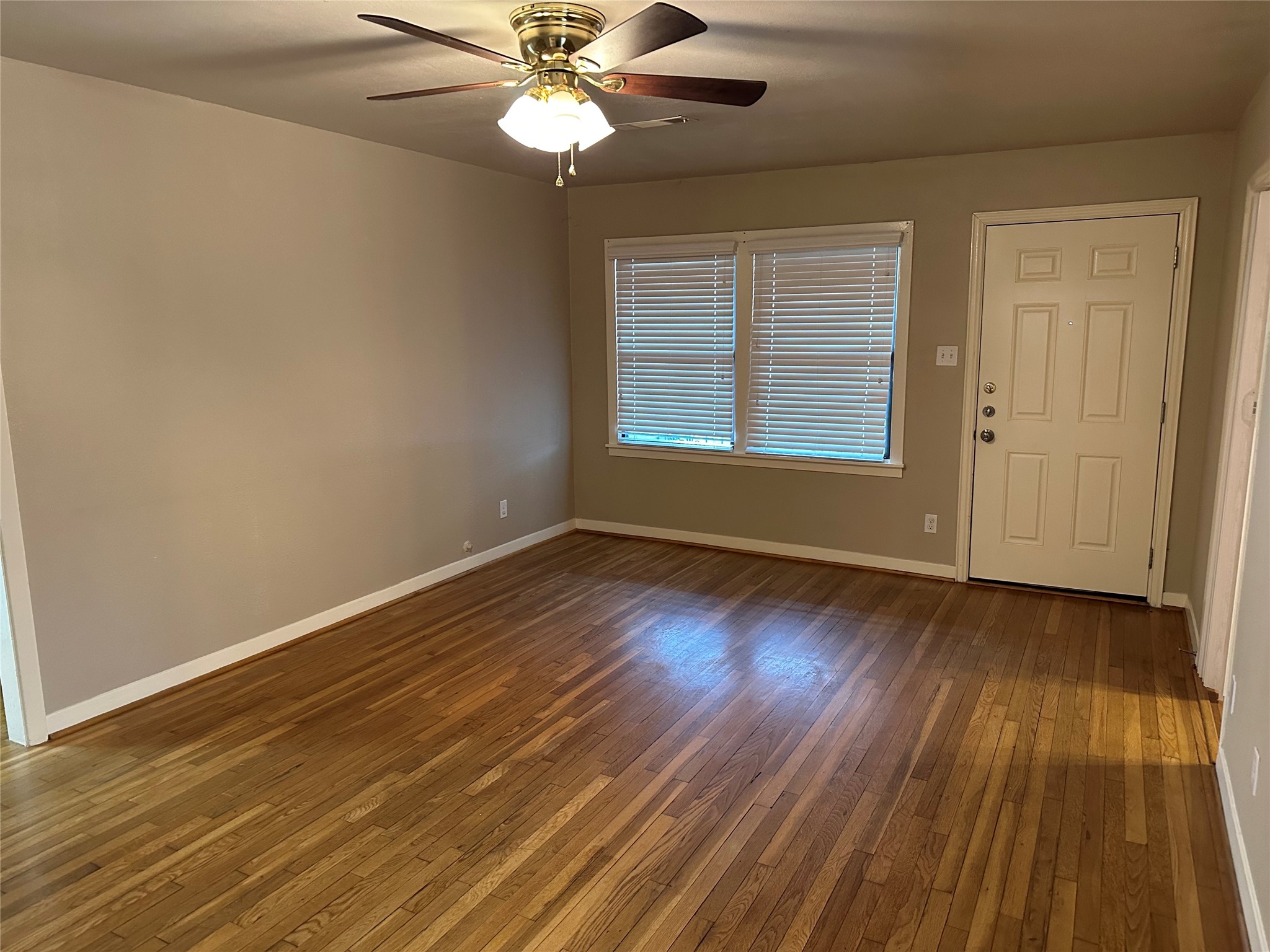 4214 Gano Street Houston, TX 77009 - Photo 2 of 12 a view of an empty room with wooden floor and a window