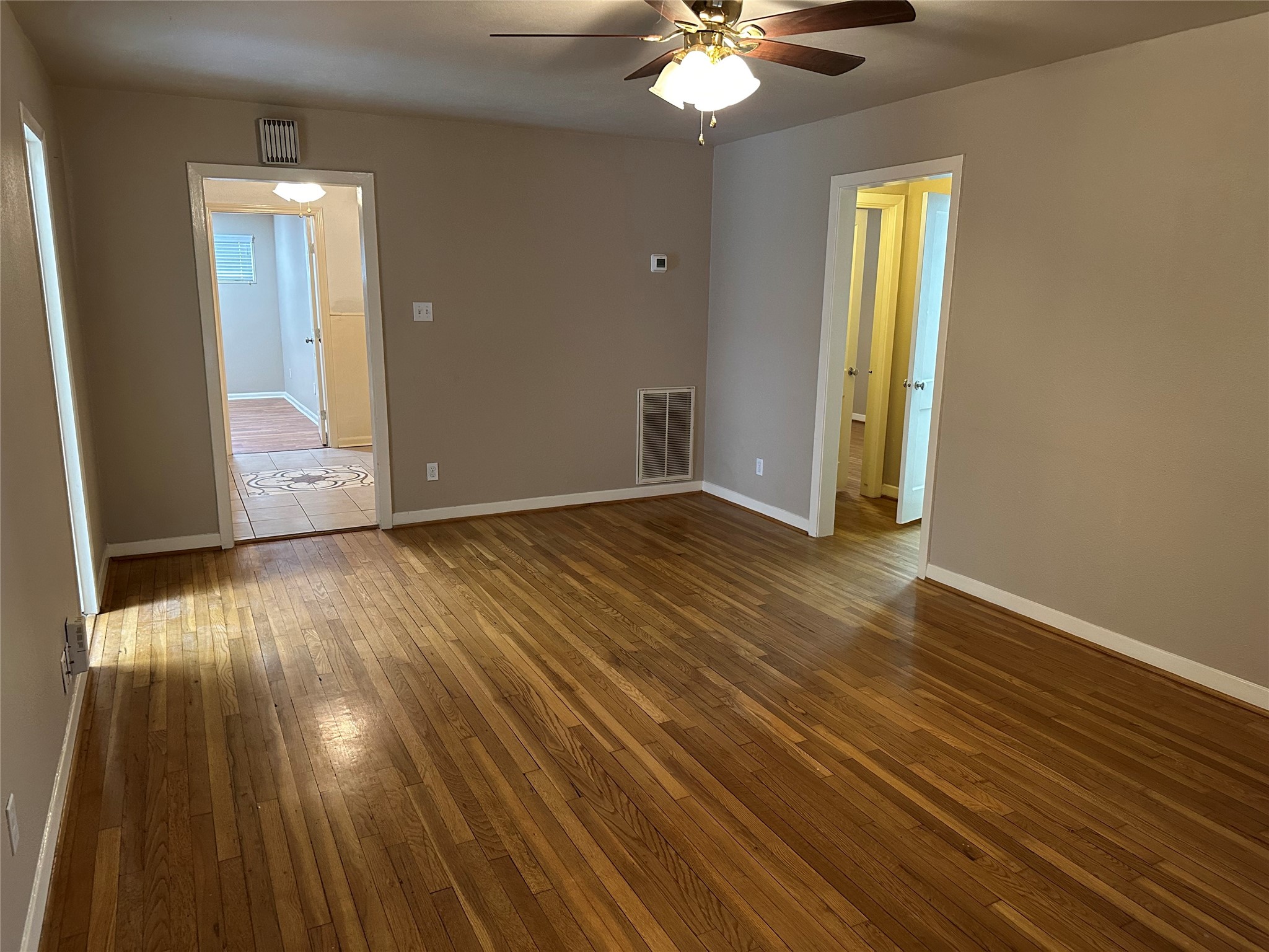4214 Gano Street Houston, TX 77009 - Photo 3 of 12 a view of an empty room with wooden floor and a window