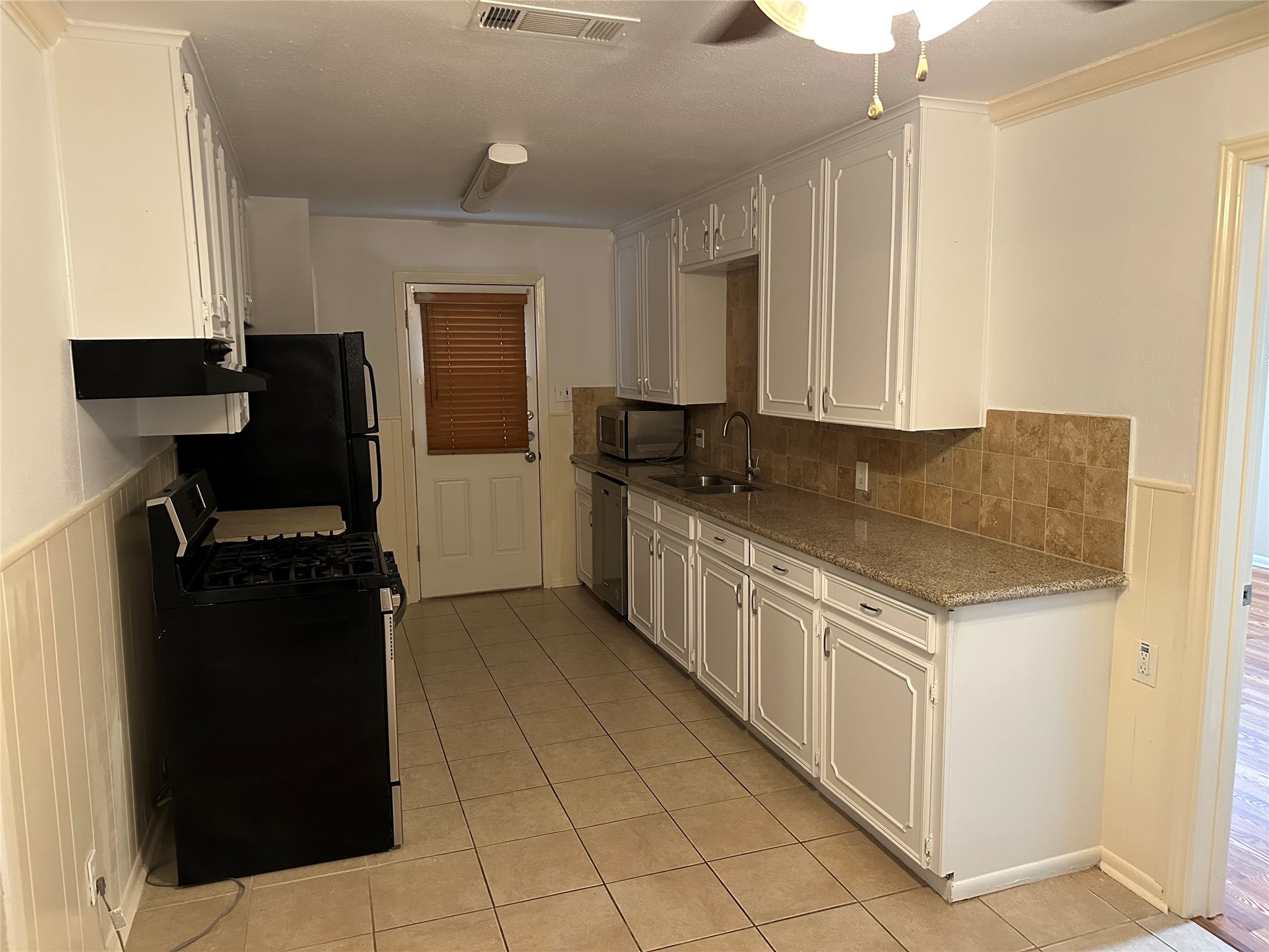 4214 Gano Street Houston, TX 77009 - Photo 5 of 12 a kitchen with granite countertop a refrigerator and a stove