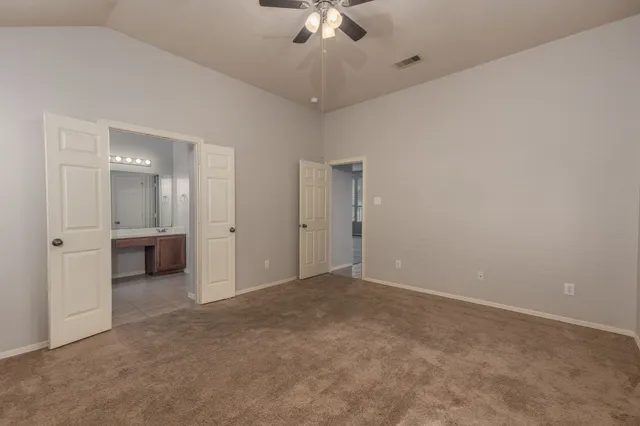an empty room with a ceiling fan and bathroom