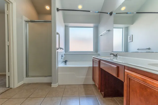 a spacious bathroom with a bathtub sink and mirror