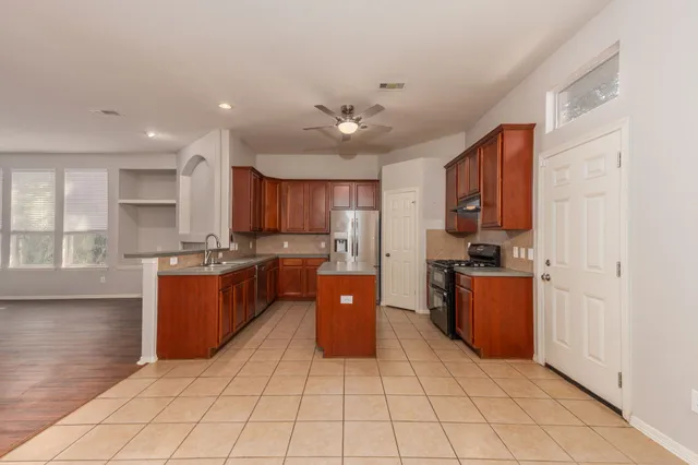 a kitchen with stainless steel appliances granite countertop a refrigerator and a stove top oven