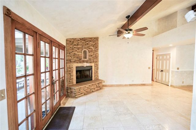 a living room with furniture a fireplace and a floor to ceiling window