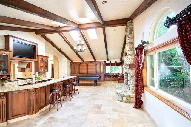 a dining hall with stainless steel appliances granite countertop a stove a sink a dining table and chairs