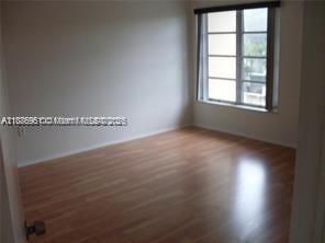 4166 Inverrary Drive, Unit 405 Lauderhill, FL 33319 - Photo 4 of 11 an empty room with wooden floor and windows