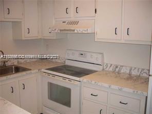 4166 Inverrary Drive, Unit 405 Lauderhill, FL 33319 - Photo 5 of 11 a kitchen with white cabinets and sink