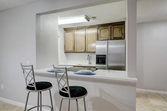 a kitchen with a refrigerator a stove and white cabinets
