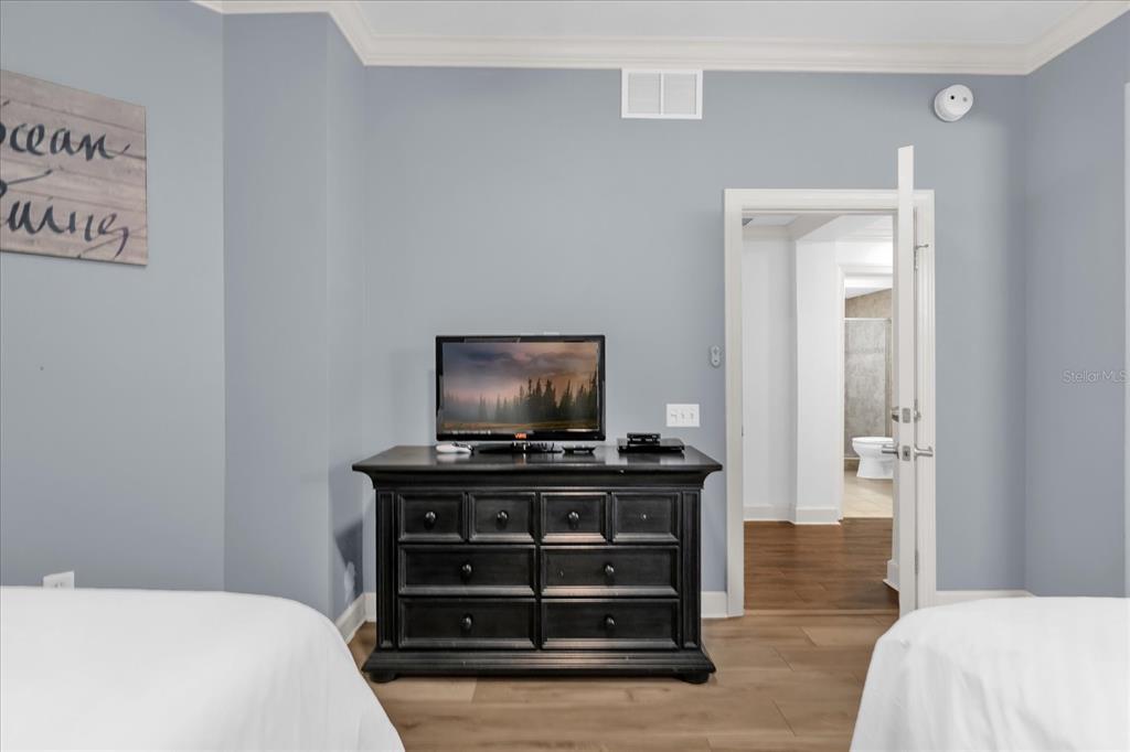 1362 Centre Ct Ridge Drive, Unit 102 Reunion, FL 34747 - Photo 21 of 35 a bedroom with a bed and a flat screen tv