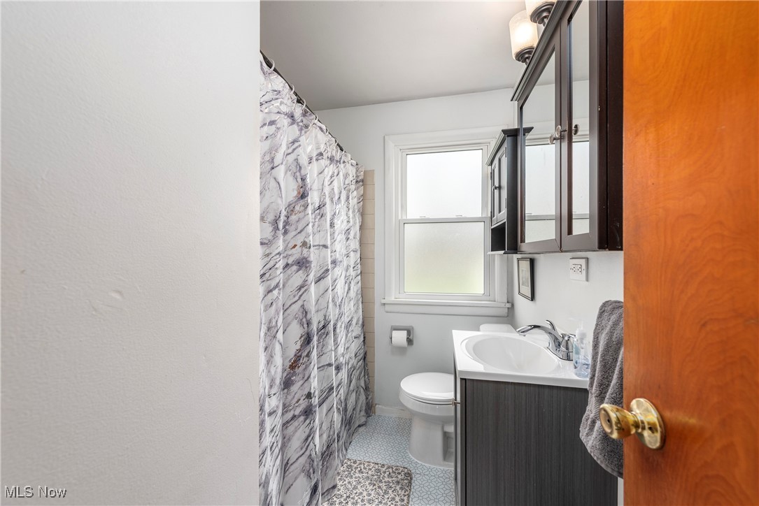 4903 Center Road Brunswick, OH 44212 - Photo 13 of 45 Full bath with toilet, vanity, curtained shower, and tile patterned floors