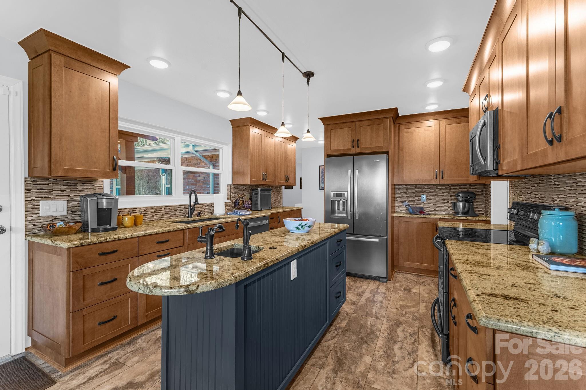 87 Rockwood Road Waynesville, NC 28786 - Photo 17 of 45 a kitchen with stainless steel appliances granite countertop a sink a stove and a refrigerator