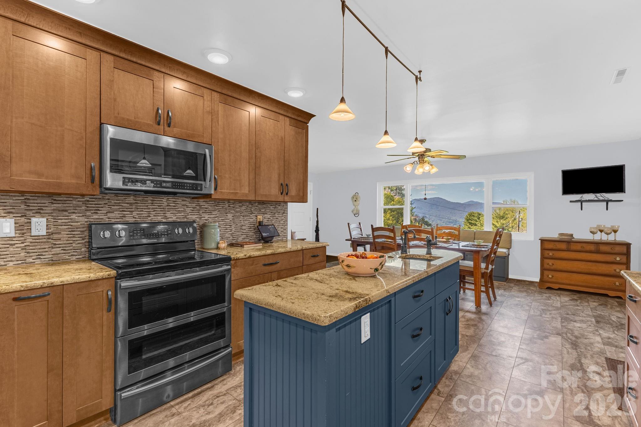 87 Rockwood Road Waynesville, NC 28786 - Photo 19 of 45 a kitchen with kitchen island granite countertop a stove oven and a wooden cabinets