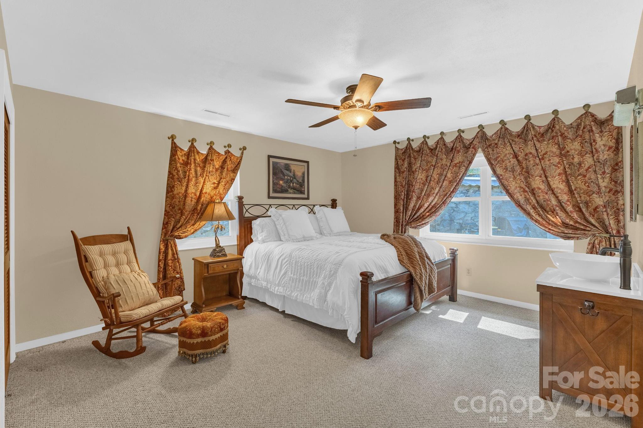 87 Rockwood Road Waynesville, NC 28786 - Photo 25 of 45 a bedroom with a bed a chair and a chandelier