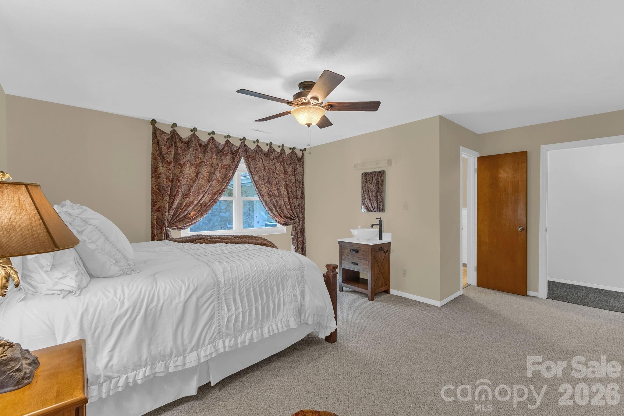 87 Rockwood Road Waynesville, NC 28786 - Photo 26 of 45 a bedroom with a bed and a chandelier