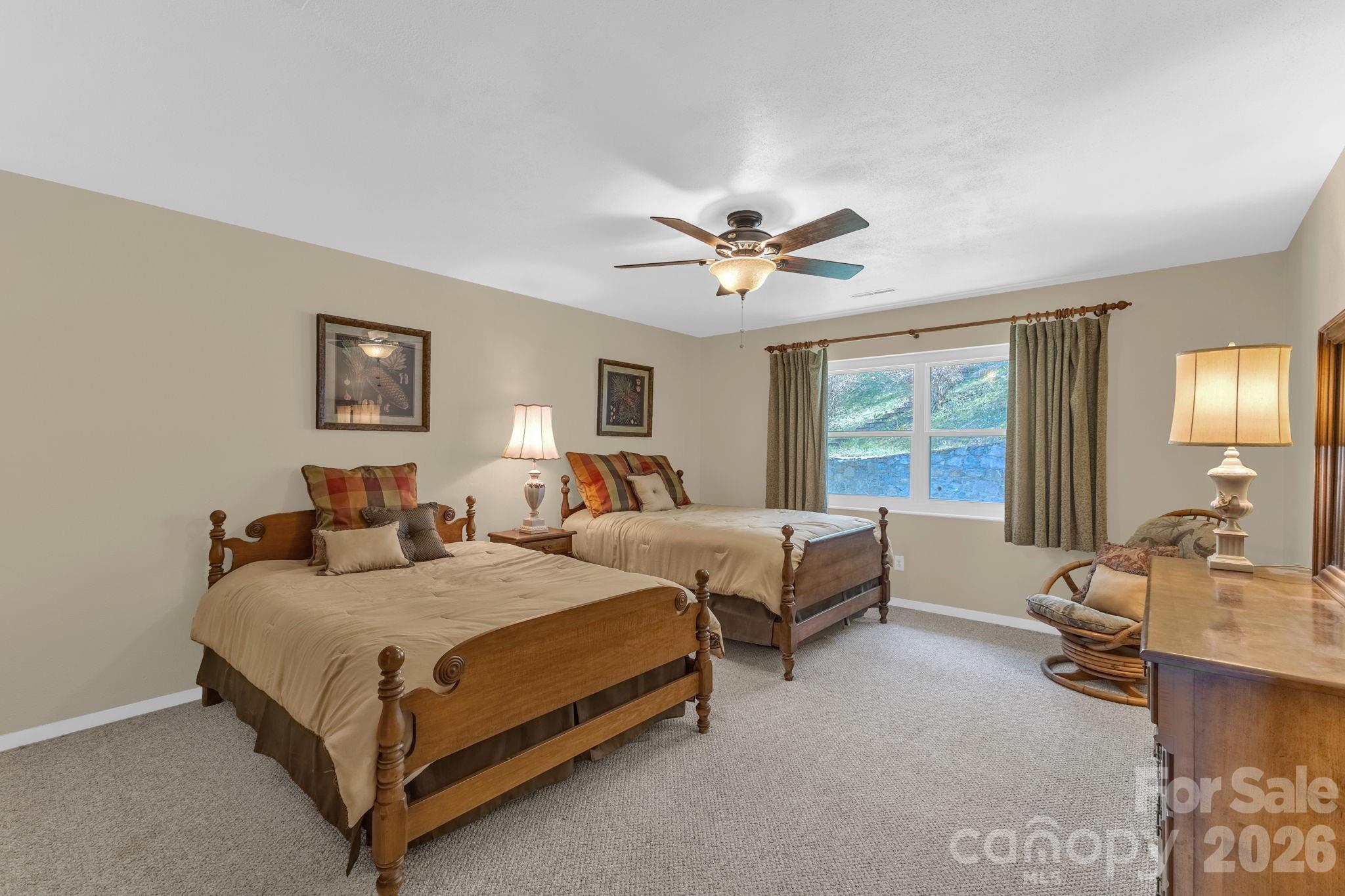 87 Rockwood Road Waynesville, NC 28786 - Photo 28 of 45 a spacious bedroom with a bed a window and a chandelier