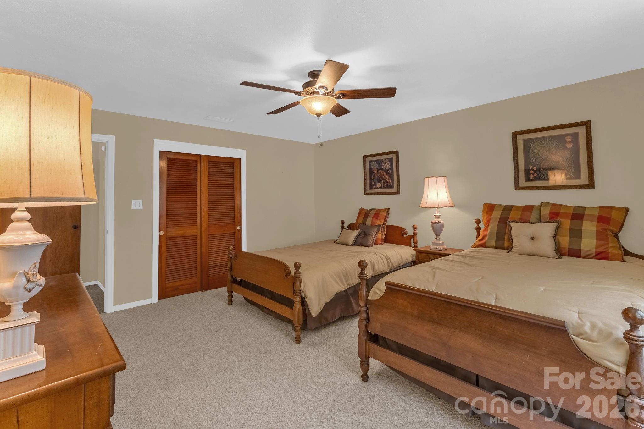87 Rockwood Road Waynesville, NC 28786 - Photo 29 of 45 a spacious bedroom with two beds and a chandelier