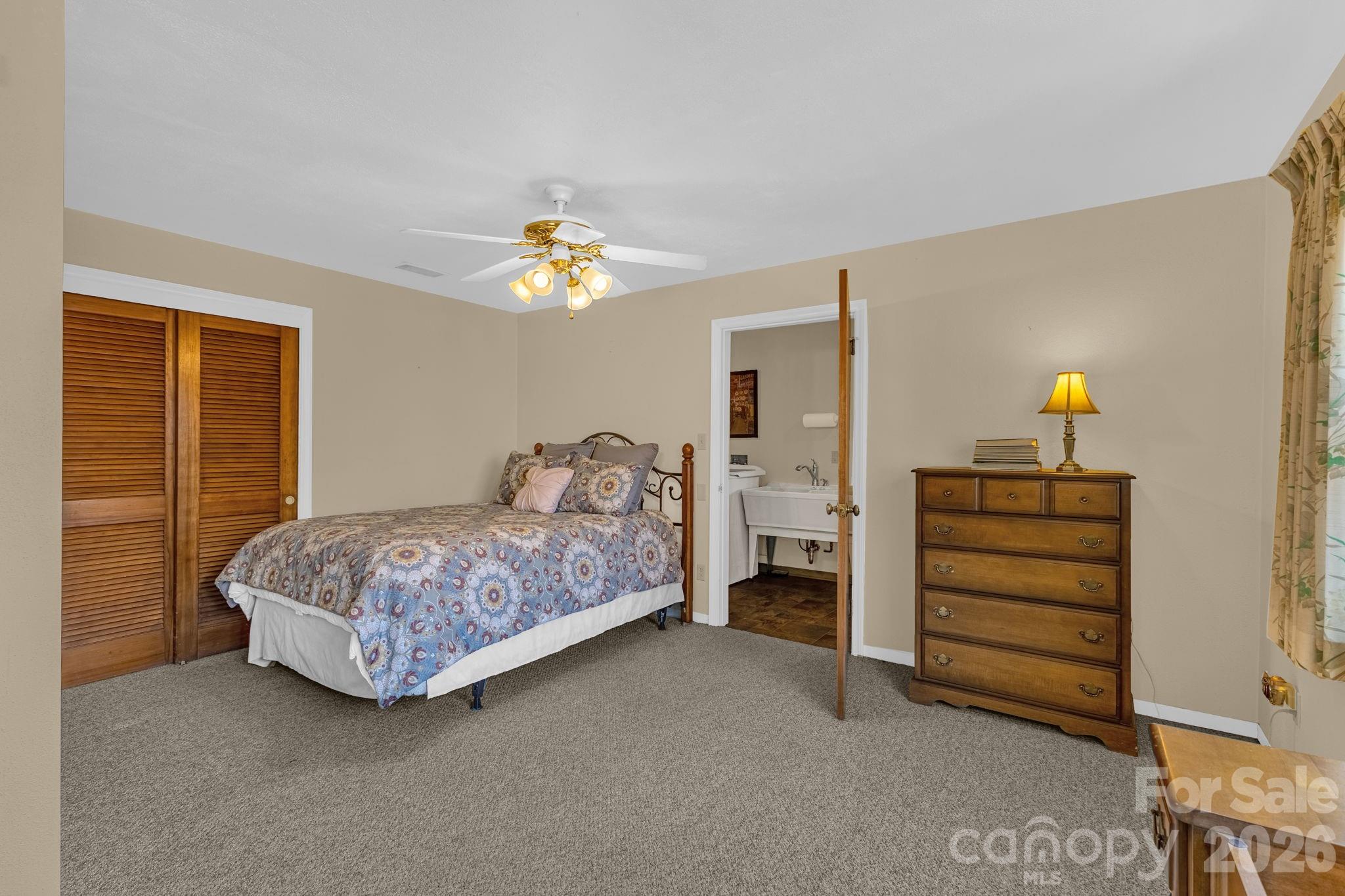 87 Rockwood Road Waynesville, NC 28786 - Photo 32 of 45 a bedroom with a bed and a chandelier