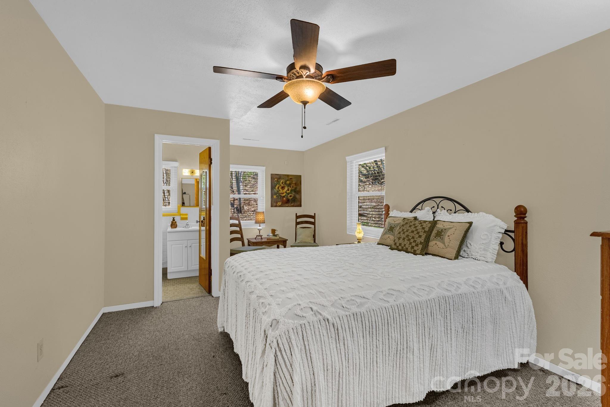 87 Rockwood Road Waynesville, NC 28786 - Photo 34 of 45 a bedroom with a bed and a chandelier