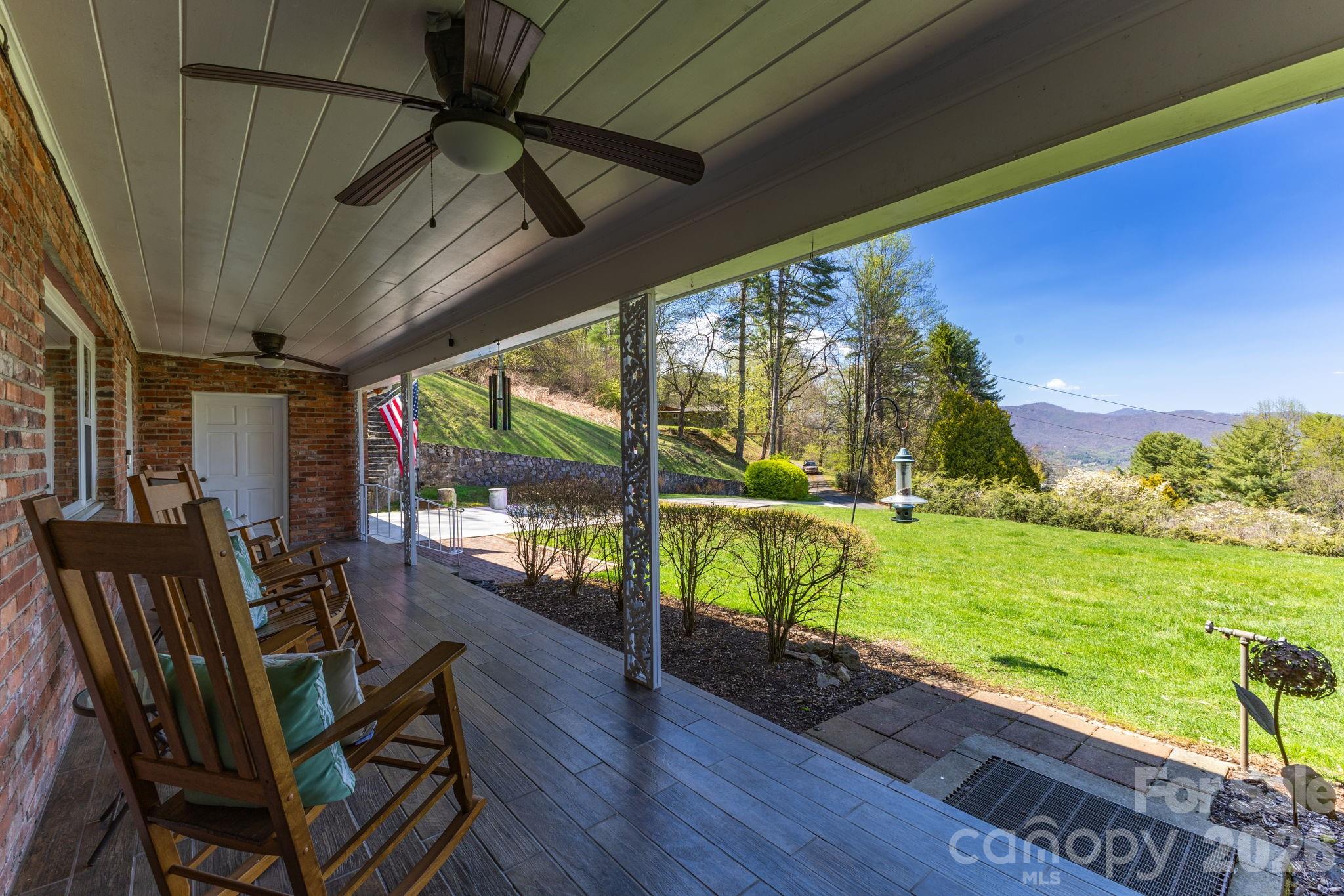 87 Rockwood Road Waynesville, NC 28786 - Photo 6 of 45 a view of a patio with lawn chairs floor to ceiling window with wooden floor