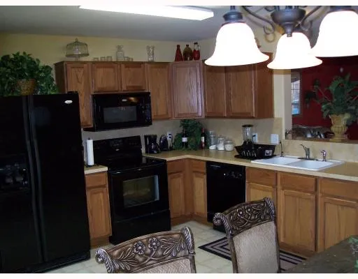 a kitchen with stainless steel appliances a stove a sink a microwave a refrigerator and cabinets