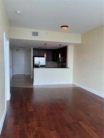 a view of empty room with wooden floor and window