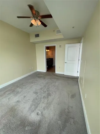 an empty room with a ceiling fan and a window