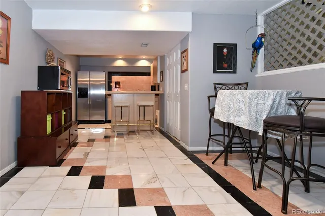 a kitchen with a black white checkered floor with a dining table and chairs