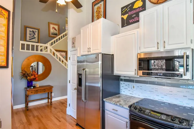 a kitchen with stainless steel appliances granite countertop a refrigerator and a stove top oven