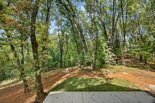 an aerial view of residential house with outdoor space and trees all around